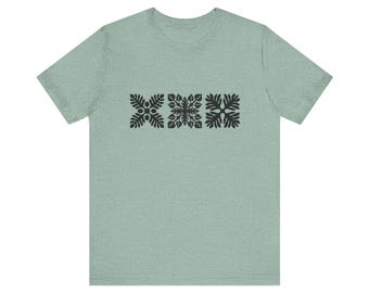 May include: A light green t-shirt with a black floral design on the front.