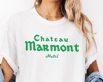 以下が含まれることがあります： 「シャトー・マルモンホテル」と緑色の文字で書かれた白いTシャツ