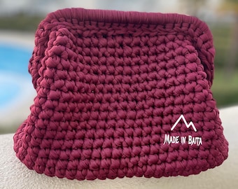 May include: A burgundy crocheted bag with a white logo that says "MADE IN BAITA" on the front.
