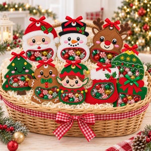 May include: A woven wicker basket filled with eight felt Christmas ornaments, each featuring a clear window filled with small round candies. The ornaments include Santa, a snowman, a reindeer, a tree, a gingerbread person, an elf, a stocking, and a gift.