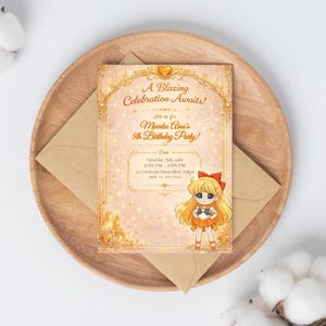 May include: A birthday party invitation featuring a cartoon character in an orange and blue outfit. The invitation has the text "A Blazing Celebration Awaits!" and "Minako Aino's 5th Birthday Party!" on a pink background with gold accents. The invitation is on a wooden tray.