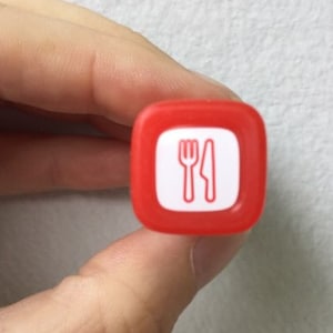 May include: Red square-shaped stamp with a white fork and knife symbol.