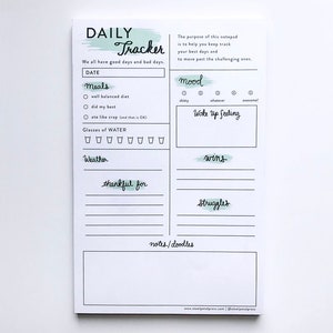 Può includere: Un blocco note bianco per il tracker giornaliero con un design ad acquerello verde. Il blocco note ha sezioni per la data, i pasti, i bicchieri d'acqua, il tempo, l'umore, la sensazione al risveglio, le vittorie, le difficoltà e le note/scarabocchi.