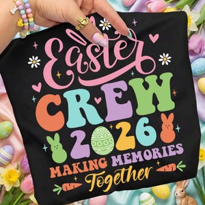 Pode incluir: T-shirt preto com as palavras "Easter CREW 2026" em letras coloridas e divertidas. O design inclui ovos de Páscoa, coelhos e cenouras, com a frase "Making Memories Together".