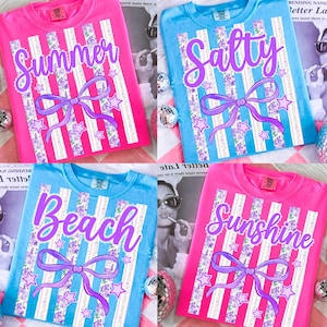 May include: Four brightly coloured t-shirts with summer-themed designs. Each shirt displays a different word: "Summer", "Salty", "Beach", and "Sunshine" in purple script. The designs include vertical stripes, a bow, stars, and floral accents.