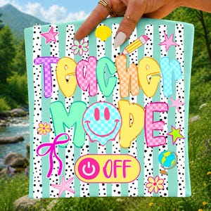 May include: A colorful, patterned fabric with the words "Teacher Mode OFF" in bubble letters. The design includes a smiley face, stars, flowers, and a globe. The background has vertical stripes and polka dots.