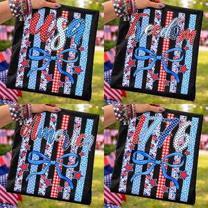 Puede incluir: Cuatro cojines cuadrados negros con diseños patrióticos. Cada cojín presenta una palabra o número diferente: "USA", "Freedom", "America" y "1776". Los diseños incluyen patrones rojos, blancos y azules, estrellas y un lazo azul.