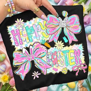 May include: Black t-shirt with a colorful "Happy Easter" design. The design features large pink bows with bunny ears, flowers, carrots, and Easter eggs. The text is in a playful, multi-colored font, perfect for Easter celebrations.