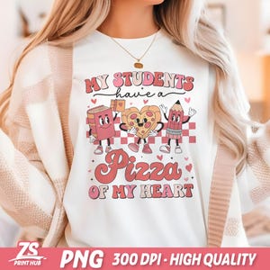 K&ouml;nnte beinhalten: Wei&szlig;es T-Shirt mit einem pinkfarbenen und roten Grafikdesign, auf dem "Meine Sch&uuml;ler haben eine Pizza meines Herzens" steht. Die Grafik zeigt ein Buch, ein Pizzast&uuml;ck und einen Bleistift mit Gesichtern.