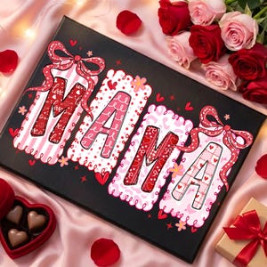 May include: A black canvas print with the word "MAMA" in pink and red letters. Each letter is decorated with patterns and bows. The canvas is surrounded by roses, rose petals, and a heart-shaped box of chocolates.