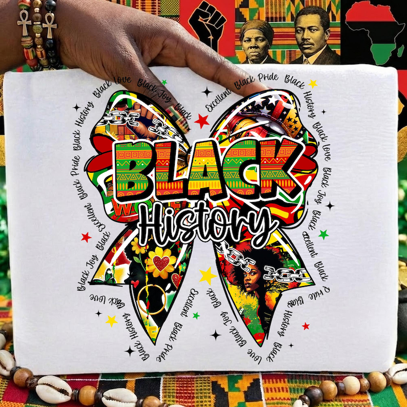 May include: White t-shirt featuring a colorful bow design with the words "BLACK History" in bold letters. The bow incorporates various patterns and images, with additional text around the bow. The shirt is held by a hand.