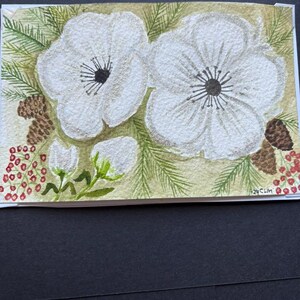 ¡Original! Tarjeta navideña con flores blancas de invierno pintada en acuarela