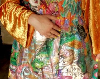 May include: A long-sleeved coat featuring a vibrant, multi-colored abstract print with painted figures and birds. The garment has solid gold-colored crushed velvet sleeves and a front button closure, showcasing a complex, layered artistic design.