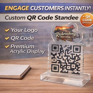 Peut inclure: Un présentoir personnalisé en acrylique transparent avec code QR. Le texte "ENGAGE CUSTOMERS INSTANTLY!" et "Custom QR Code Standee" sont visibles. Il affiche un code QR, un logo et les mots "Your Logo", "QR Code", et "Premium Acrylic Display".