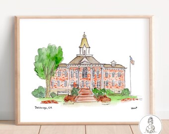 May include: Watercolor painting of a brick building with a tall tower and a clock face. The building is surrounded by trees and grass. The text "Dahlonega, GA" is written below the building.