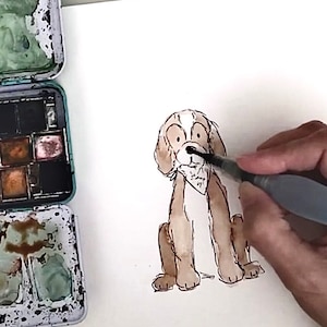 May include: A hand paints the nose of a brown and white dog illustration with a black watercolor brush. The dog is sitting with its legs crossed and has a white bandana around its neck.