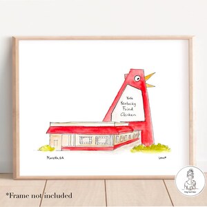 Op de afbeelding: Een aquarelillustratie van een rood Kentucky Fried Chicken-gebouw met een groot rood kippenbeeld. Het gebouw heeft een bord met de tekst "Kentucky Fried Chicken" en "Mansetta, GA".