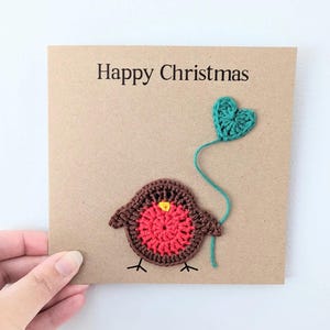 Handgemachte personalisierte Weihnachtskarte mit gehäkeltem Rotkehlchen mit Herzballon
