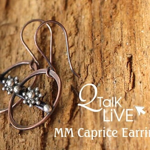 May include: A pair of copper and silver earrings with a circle design and small silver beads. The earrings are on a wooden surface.  MM Caprice Earrings.