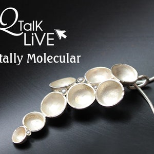 May include: A silver-toned pendant necklace with a unique, molecular-inspired design. The pendant features a series of connected, open-faced, bowl-shaped elements, accented with small, round details. The necklace is on a black background. The text "Q Talk LIVE Totally Molecular" is in the upper left.