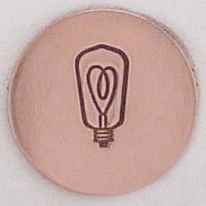 May include: A metal stamp with a design of an old-fashioned light bulb.