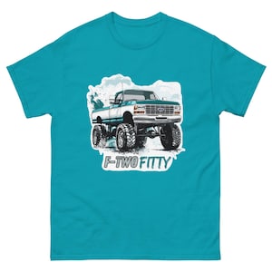 May include: Teal t-shirt featuring a graphic of a lifted, two-tone pickup truck with the text "F-TWO FIFTY" in white. The truck is white and teal, with large black tires. The design is set against a light blue background.