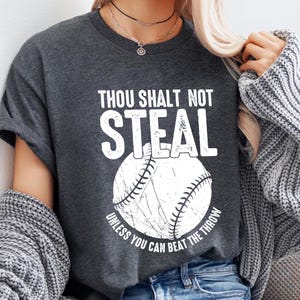 May include: A gray t-shirt with the text "Thou Shalt Not Steal Unless You Can Beat The Throw" and a white baseball graphic.