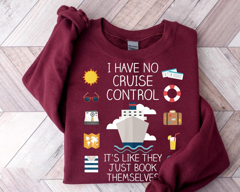 A burgundy sweatshirt with a humorous text and various icons related to travel and cruise control.