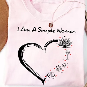 May include: Pink t-shirt with the text "I Am A Simple Woman" and a black heart design. The heart is filled with images of bowling pins, a wine glass, flip flops, and paw prints.
