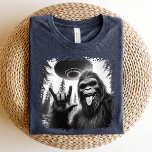 a t - shirt with a picture of a gorilla holding a frisbee