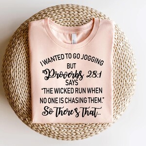 May include: A pink t-shirt with a black graphic that says "I wanted to go jogging but Proverbs 28:1 says "The wicked run when no one is chasing them." So there's that."