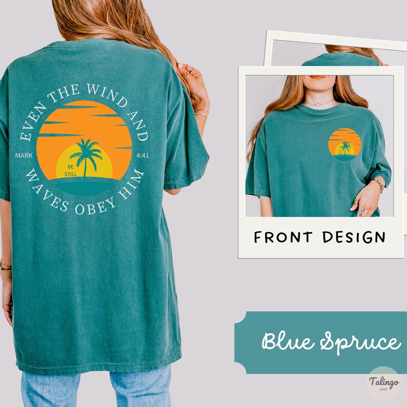May include: A teal blue t-shirt with a graphic on the back that says "Even the wind and waves obey him" with a palm tree and sunset graphic. The front of the shirt is plain teal blue.