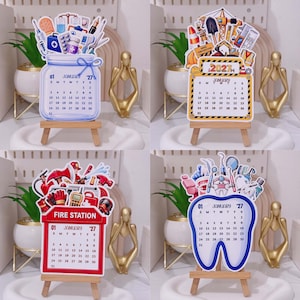 May include: Four decorative 2027 January calendars displayed on small wooden easels. The top left is a blue jar with medical icons, the top right is a construction theme, the bottom left is a red fire station theme, and the bottom right is a tooth shape.