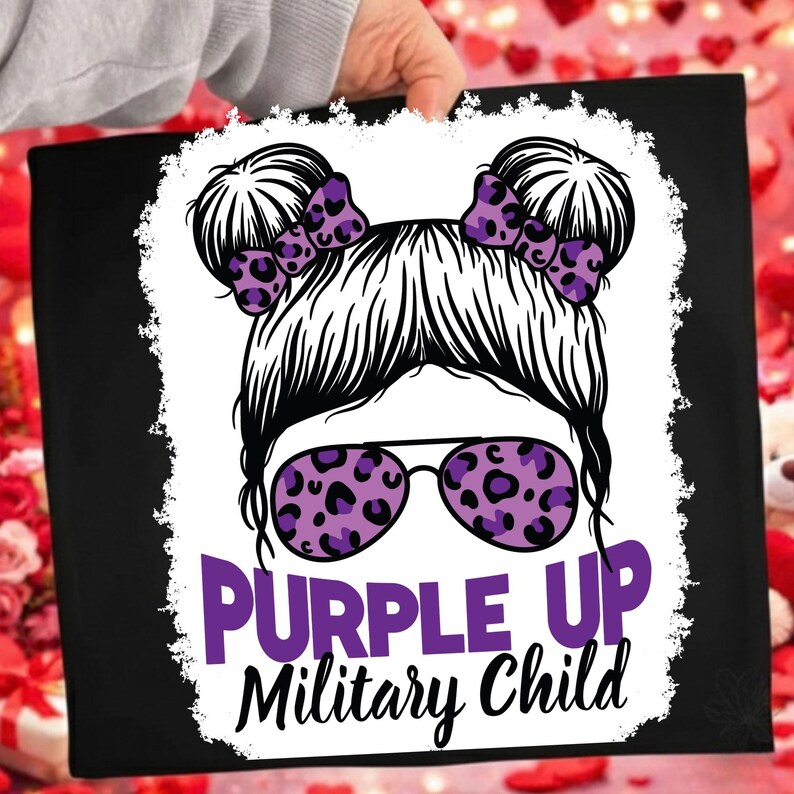 May include: Black canvas tote bag featuring a graphic of a woman's face with sunglasses and hair buns. The sunglasses and bows have a purple leopard print. The text "PURPLE UP Military Child" is in purple.