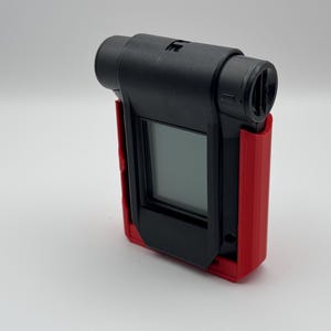 Puede incluir: Un dispositivo negro y rojo con una pantalla y un micrófono. El dispositivo está en una funda protectora.