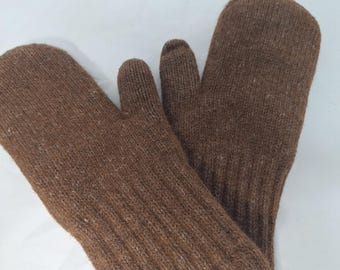 Könnte beinhalten: Ein Paar braune Strickfäustlinge. Die Fäustlinge bestehen aus einem strukturierten, gerippten Strickstoff. Der Daumen ist von den anderen Fingern getrennt. Die Fäustlinge sind so konzipiert, dass sie die Hände bei kaltem Wetter warm halten.