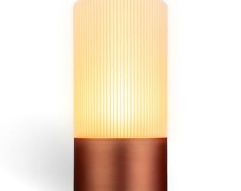 May include: A modern table lamp with a white ribbed shade and a copper base.