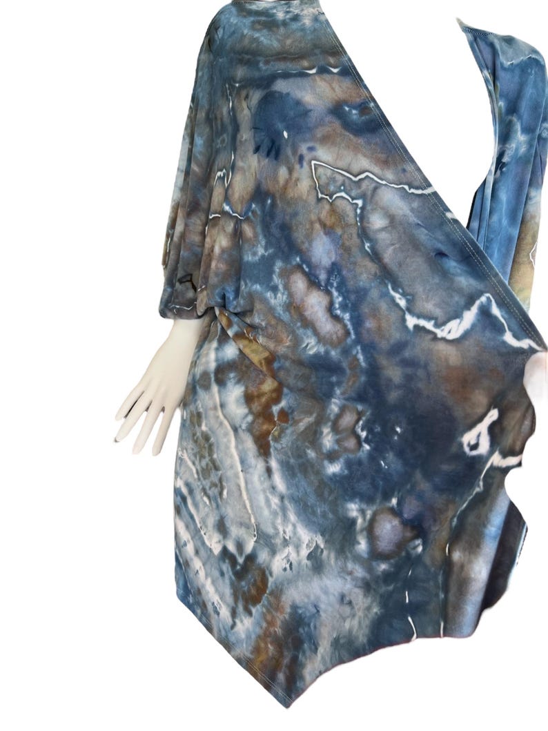 Pode incluir: Um top de envolver azul e marrom com estampa tie-dye, decote em V e mangas curtas.