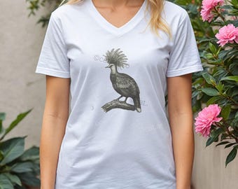 May include: White V-neck t-shirt with a black and white illustration of a bird on a branch. The bird has a prominent feathered crest. The text "@cat.art." is printed on the shirt.