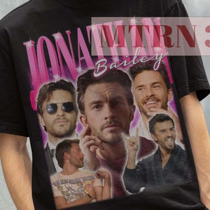 May include: Black t-shirt with a collage of images of Jonathan Bailey, the actor who plays Anthony Bridgerton in the Netflix series Bridgerton. The t-shirt has the text "Jonathan Bailey" printed on it in pink.