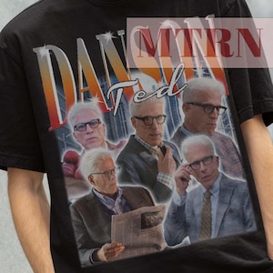 Puede incluir: Camiseta negra con un estampado gráfico de un hombre con gafas y traje. El estampado gráfico dice "Dan Rather" y "Ted".