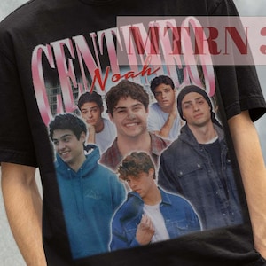 Peut inclure: T-shirt noir avec un imprimé graphique d'un groupe de personnes, incluant le texte "Noah" et "CENTIMERN 38".