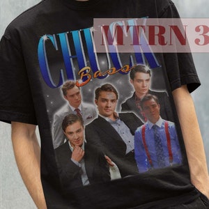 May include: Black t-shirt featuring a vintage-style graphic of the cast from the TV show "Gossip Girl" with the text "Chuck Bass" on it. The graphic is in blue, red, and white.