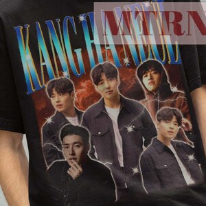 Könnte beinhalten: Schwarzes T-Shirt mit einem Gruppenfoto und dem Wort "KANG" in einem blau-orangen Farbverlauf. Die Person, die das T-Shirt trägt, trägt auch einen schwarzen Fischerhut. Der Text "MTRN 38" ist ebenfalls sichtbar.