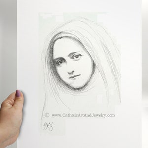 May include: A black and white pencil drawing of a woman's face. The woman is wearing a veil and has a soft expression. The drawing is signed in the bottom right corner with the text "www.CatholicArtAndJewelry.com".