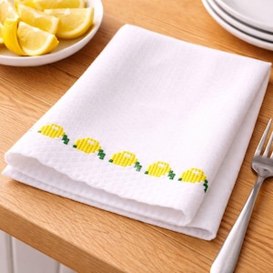 Puede incluir: Una taza de cerámica blanca con un asa negra y el texto "But First, Coffee" en negrita negra. La taza se encuentra sobre un fondo borroso, sugiriendo un ambiente acogedor.