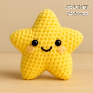 Puede incluir: Una estrella amarilla hecha a mano con ganchillo, con ojos de botón negros, una boca sonriente y mejillas color melocotón. El texto "CROCHET PATTERN" se muestra en blanco. Esta suave y afelpada estrella es un artículo hecho a mano encantador.