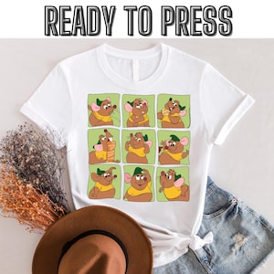 Peut inclure: T-shirt blanc avec un imprimé graphique d'une souris de dessin animé dans neuf poses différentes. La souris porte un chapeau vert et une chemise jaune. Le texte "READY TO PRESS" est en haut de l'image.