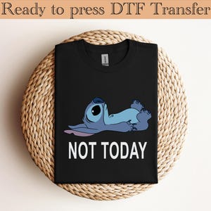 K&ouml;nnte beinhalten: Ein schwarzes T-Shirt mit einer Grafik einer blauen Figur, die auf dem R&uuml;cken liegt, darunter der Text NOT TODAY in wei&szlig;en Gro&szlig;buchstaben. Das T-Shirt hat einen Rundhalsausschnitt und einen klassischen Schnitt mit kurzen &Auml;rmeln.