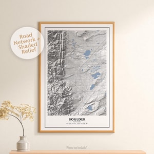 May include: A framed map of Boulder, Colorado, with a shaded relief design showing the city's topography. The map includes a road network and the coordinates 40°00′54″N 105°16′14″W.